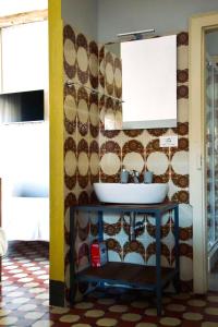 La salle de bains est pourvue d'un lavabo et d'un mur en carrelage. dans l'établissement Bed and Breakfast da Peppino, à Bianchi