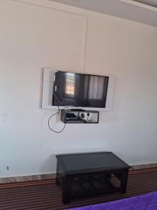 a flat screen tv on a wall with a table at Royal homes a4 in Kushālnagar