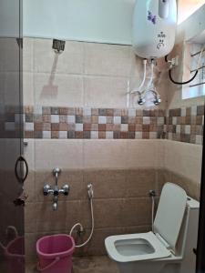 a bathroom with a toilet and a pink bucket at Royal homes a4 in Kushālnagar