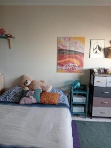 a teddy bear sitting on a bed in a bedroom at Appartement lumineux et confort ! in Pantin