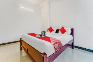 a bedroom with a bed with red pillows at Flagship Cruze Residency in Coimbatore