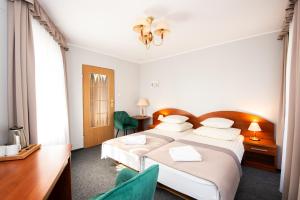 ein Hotelzimmer mit einem Bett, einem Schreibtisch und Stühlen in der Unterkunft Rewita Miedzyzdroje - MORSKIE OKO in Misdroy