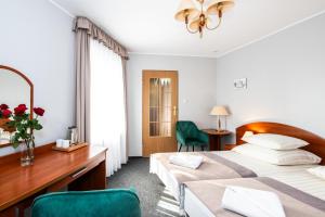 ein Hotelzimmer mit zwei Betten und einem Schreibtisch in der Unterkunft Rewita Miedzyzdroje - MORSKIE OKO in Misdroy
