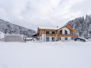 Luxury Chalet in Saalbach Hinterglemm with Sauna في سالباخ هينترغليم: منزل في الثلج مع اشجار في الخلفية