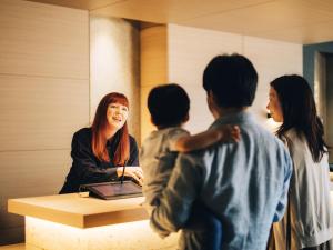 MIMARU TOKYO NIHOMBASHI SUITENGUMAE في طوكيو: امرأة تقف في مكتب مع أربعة أطفال