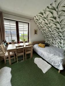 ein Schlafzimmer mit einem Tisch und einem Bett sowie ein Esszimmer in der Unterkunft Rumiankowa Bis in Puck