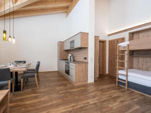 ザールバッハ・ヒンターグレムにあるLuxury Chalet in Saalbach Hinterglemm with Saunaの二段ベッド1組、ダイニングテーブルが備わる小さなアパートメントです。