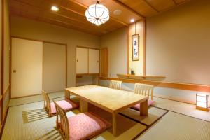 uma sala de jantar com uma mesa de madeira e cadeiras em Maruei em Fujikawaguchiko