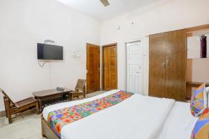 Schlafzimmer mit einem Bett, einem Schreibtisch und einem TV in der Unterkunft FabExpress Corporate Stays in Ranchi
