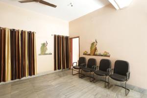una sala de espera con 4 sillas y un espejo en FabExpress Corporate Stays en Ranchi