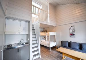 a tiny house with a staircase and a bunk bed at Evjetun in Evje