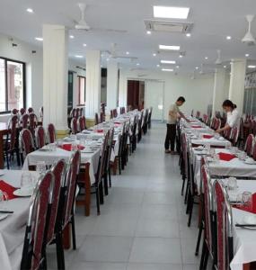 two men standing in a dining room with tables and chairs at Khách sạn Viễn Đông in Dong Quan