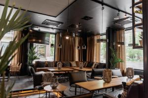 Original Sokos Hotel Puijonsarvi في كوبيو: مطعم به طاولات و كنب وكراسي