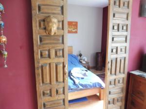 une porte en bois menant à une chambre avec un lit dans l'établissement art Lançon, à Lançon-Provence