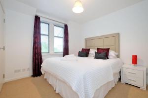 a white bedroom with two beds and a window at Lovely Aberdeen Home close to the Scottish Coast in Aberdeen