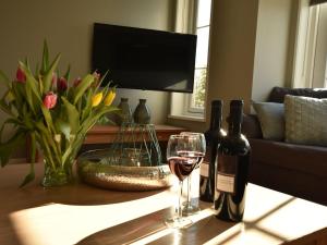 a table with two bottles and a glass of wine at Luxurious Villa in Schoorl with Garden in Schoorldam