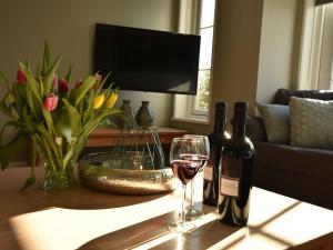 uma mesa com duas garrafas e um copo de vinho em Luxurious Villa in Schoorl with Garden em Schoorldam