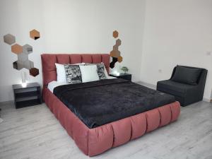 a bedroom with a large red bed and a chair at Summer day Chernomorets in Chernomorets