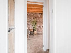 corridoio con muro di mattoni e tavolo di Spacious holiday home Hazenborgh in Callantsoog near beach a Callantsoog