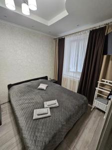 a bedroom with a bed with two towels on it at Danyla Galytskogo apartment Центр міста, старе місто 5хв in Kamianets-Podilskyi