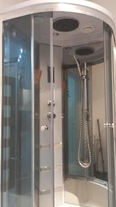 een douche met een glazen deur in de badkamer bij Borne militaria u Ewy in Borne Sulinowo