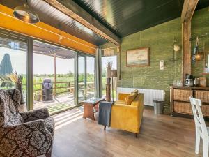 ein Wohnzimmer mit einem Sofa und einem Stuhl in der Unterkunft Quaint Bungalow in Callantsoog with Garden in Callantsoog