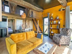 ein Wohnzimmer mit einem Sofa und einem Stuhl in der Unterkunft Quaint Bungalow in Callantsoog with Garden in Callantsoog