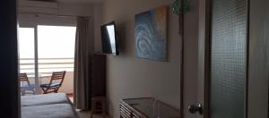 sypialnia z łóżkiem i telewizorem na ścianie w obiekcie Seafront apartment with open-air heated pool w mieście Fuengirola