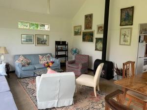 a living room with a blue couch and chairs at Lakehouse in Howick