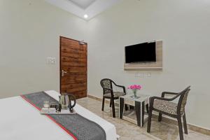 a room with two chairs and a table and a tv at Townhouse 1160 P.s.Palace Near Amausi Metro Station in Lucknow