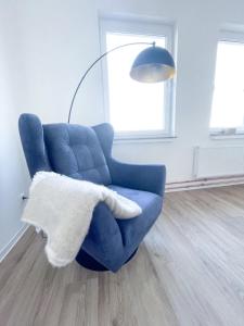 a blue chair with a white blanket sitting in a room at Ferienzimmer auf dem Hof Postma in Lambrechtshagen
