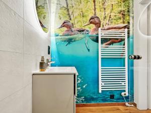 a bathroom with three ducks swimming in the water at CBlue: Seeblick, Kamin, Wallbox, Natur in Bentwisch