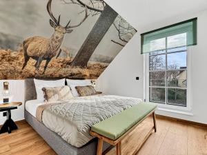 a bedroom with a bed with a deer mural on the wall at CBlue: Seeblick, Kamin, Wallbox, Natur in Bentwisch