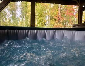 a hot tub with water in it with trees in the background at The Hideout Log Cabin- 2km to Klarälvsbanan and swimming area in Munkfors