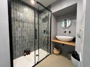 un bagno con doccia in vetro e lavandino di Pause Suite a Napoli