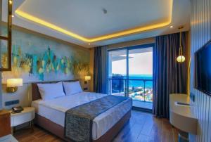 a hotel room with a bed and a large window at SEAPHORIA BEACH HOTEL & Spa - by Mir'Amor-Ultra All Inclusive in Antalya