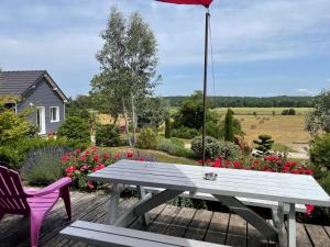 - une table de pique-nique et 2 chaises sur une terrasse fleurie dans l'établissement Gite Loire et Bois, à Saint-Martin-sur-Ocre