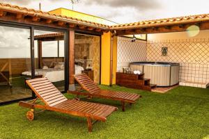 2 chaises longues assises sur une pelouse avec une chambre dans l'établissement Precioso ático con vistas al mar, à Santa Úrsula