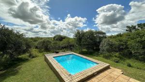 ein Schwimmbad in der Mitte eines Gartens in der Unterkunft Zululand Lodge in Hluhluwe