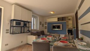 Il comprend une cuisine et un salon avec une table et des chaises. dans l'établissement Cozy Couples Apartment just 15 min from Garda Lake, à Caprino Veronese