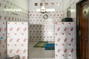 a bathroom with red and white tiled walls at Penginapan Losmen Ayu Pamanukan RedPartner in Pamanukan-hilir