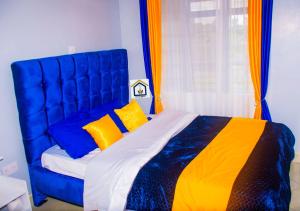 a blue bed with yellow pillows in a bedroom at Othaya Hideout in Othaya