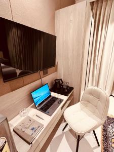 um computador portátil numa secretária com uma cadeira num quarto em The Lodgers Luxury Hotel Near Golf Course Road Gurgaon em Gurgaon