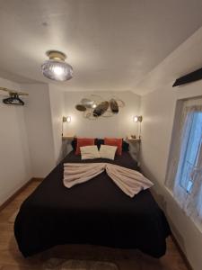 a bedroom with a large black bed in a room at LE PETIT TRIPLEX DES CARMELITES -COEUR HISTORIQUE in Rouen