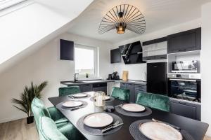 una cucina con tavolo da pranzo e sedie verdi di Roof-Suite 02 I Aufzug I BBQ I WiFi I Balkon I TV a Rheda-Wiedenbrück Altre 14 foto