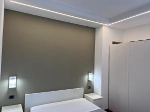 een slaapkamer met een wit bed en een spiegel bij Residence Tufilla in Ascoli Piceno
