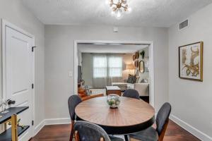 a living room with a wooden table and chairs at Modern 2 BR Condo - 2 block from San Marco in Jacksonville