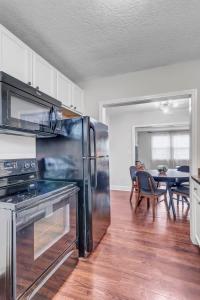 a kitchen with a stainless steel refrigerator and a table at Modern 2 BR Condo - 2 block from San Marco in Jacksonville +18 photos