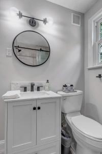 a white bathroom with a mirror and a toilet at Modern 2 BR Condo - 2 block from San Marco in Jacksonville