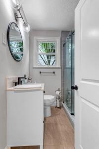 y baño con aseo, lavabo y espejo. en Modern 2 BR Condo - 2 block from San Marco en Jacksonville